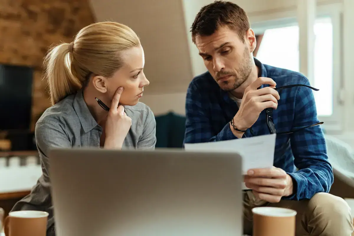 Casal conferindo contas e documentos em casa